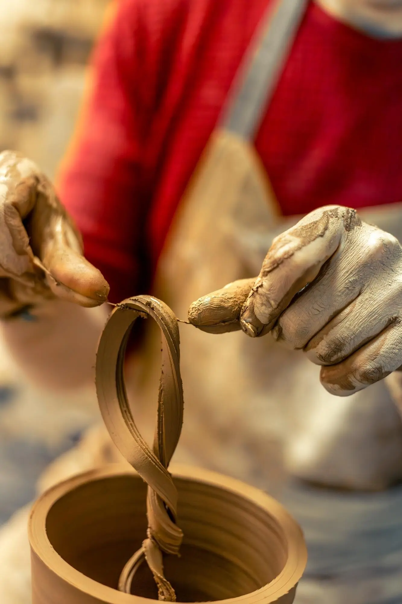 Ein männlicher Töpfer modelliert Ton, um eine Vase herzustellen, und fertigt Keramik.